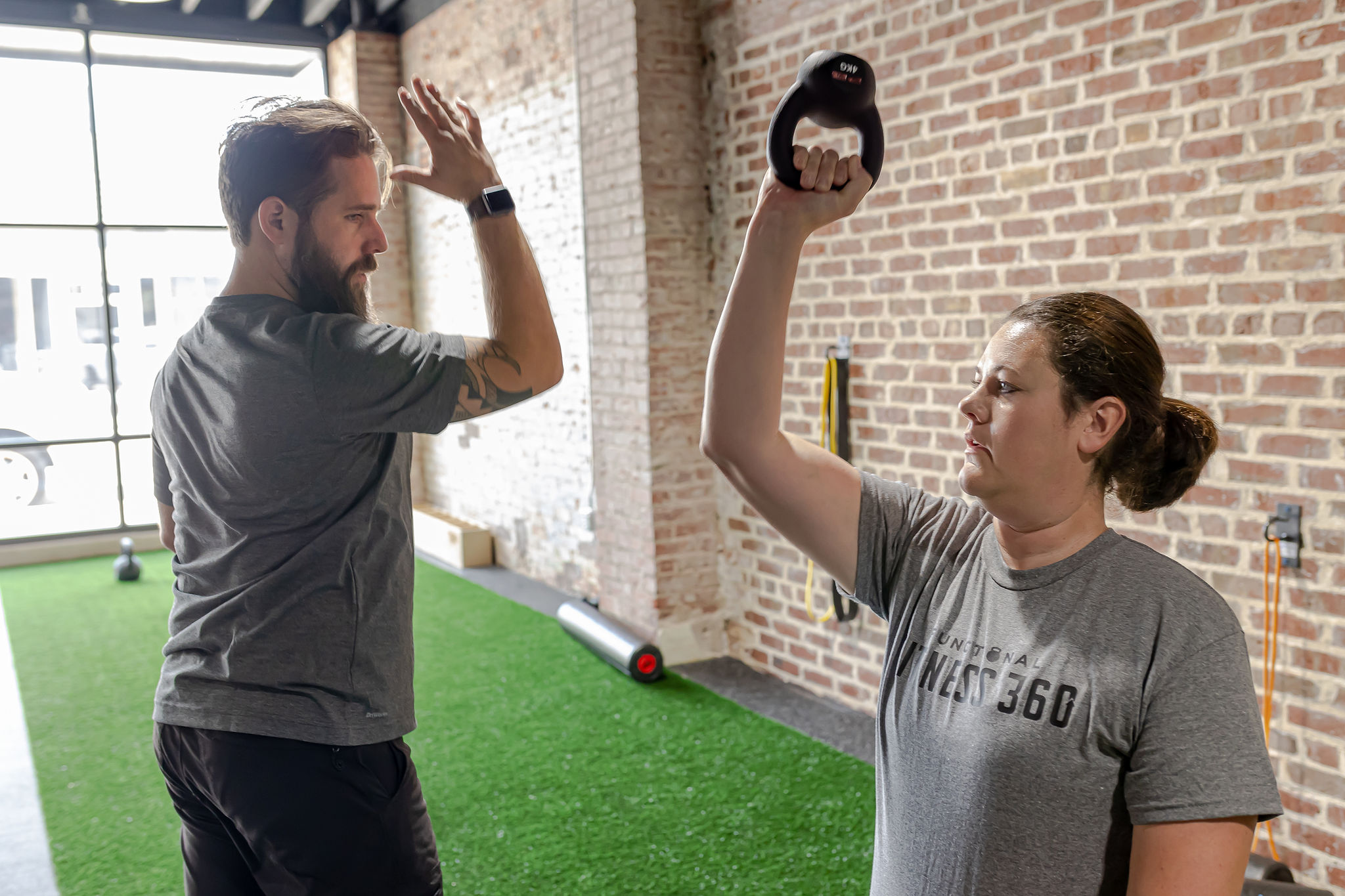 Coach Huw Meyrick guiding a member through kettlebell training